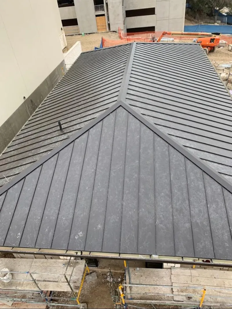 Commercial metal roof construction with crane equipment in La Feria